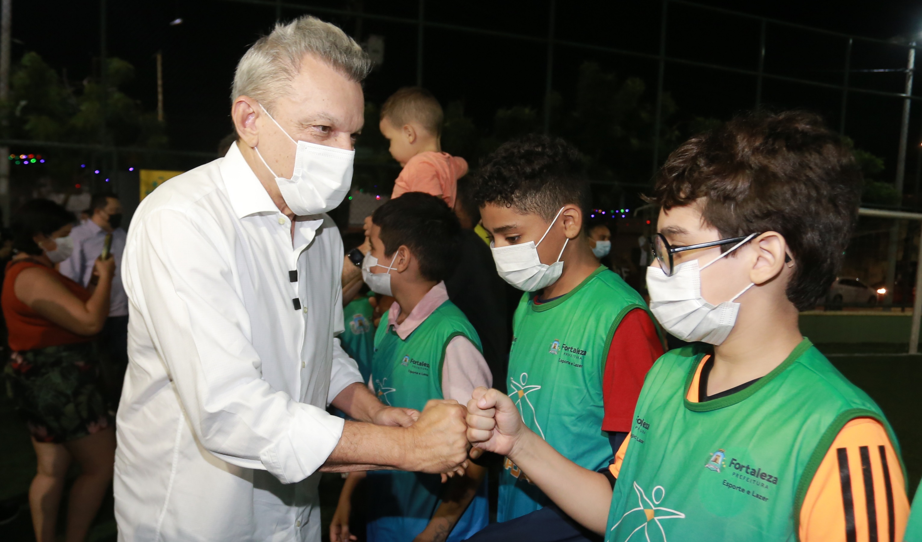 prefeito cumprimenta crianças e adolescentes na entrada da areninha